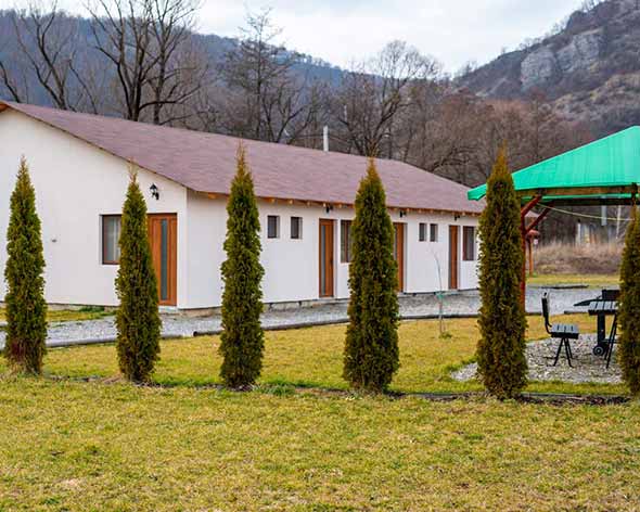 Șirul de căsuțe cu terasă al resortului, văzut de pe pajiște