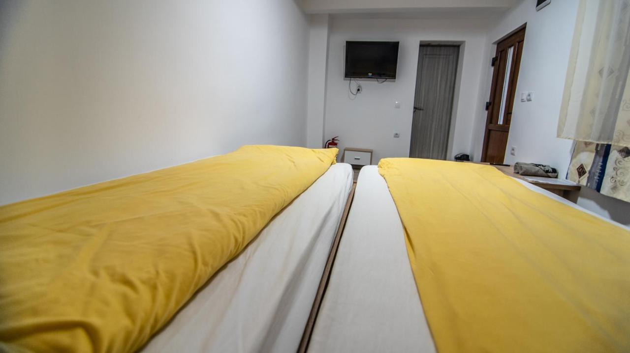 Pat dublu cu cuvertură galbenă, într-o cameră a pensiunii
