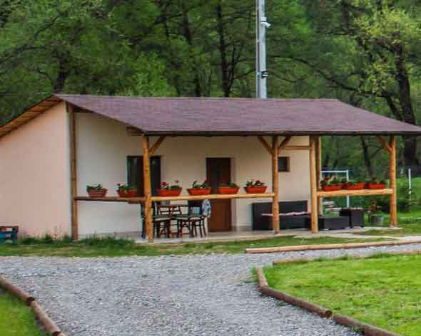 Bungalow din lemn cu terasă acoperită, la marginea pădurii