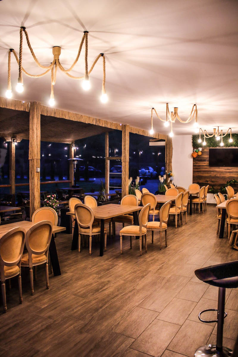 Interiorul restaurantului cu mese aranjate și lumină caldă