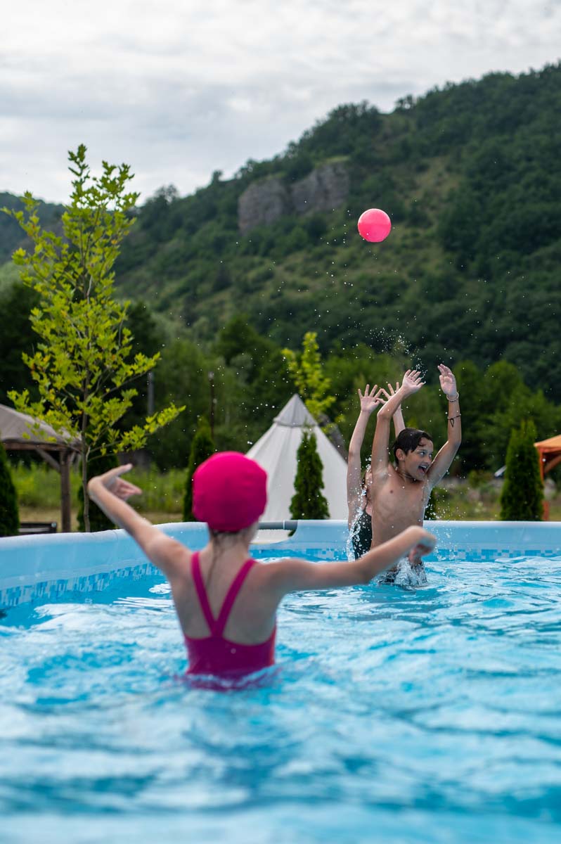 Copii jucându-se în piscina supraterană, într-o zi însorită