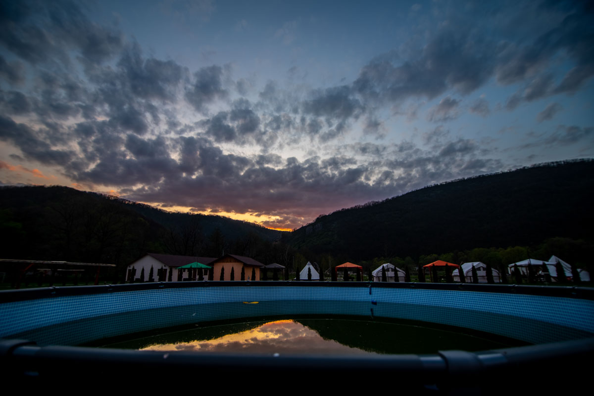 Piscina supraterană la amurg, cu munții în fundal
